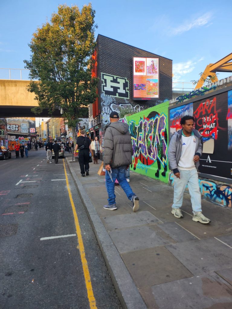 side wald with people and the billboard displaying art